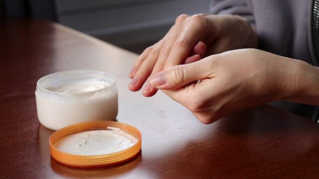 Female hands applying hand cream. Finger massage. Close-up.