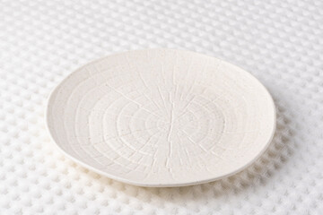 Simple white ceramic plate with textured surface designed for modern dining experiences in contemporary settings