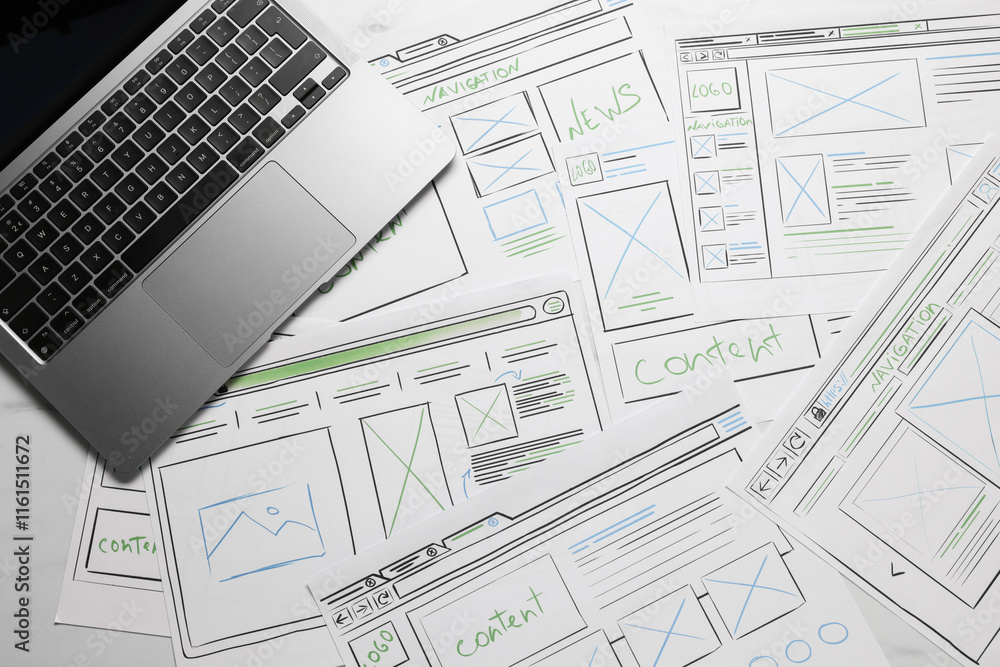 Poster developing ui design. sketches of website wireframes and laptop on table, top view