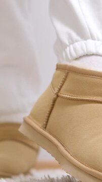 beige ugg boots Girl Waking Up Legs Feet In Bedroom. Comfort Cozy Morning. Awake Bedtime Early Morning. Female Slippers On Rug Near Sofa. Woman Legs Soft Plush Warm Slippers