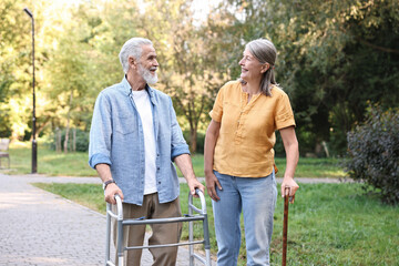 Senior couple with walking frame and cane in park