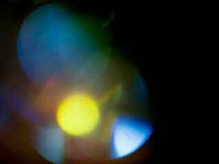 Abstract light leak effect on dark background for creating special effects. The colors are vibrant and the circles are overlapping, creating a sense of movement and energy. Abstract art.