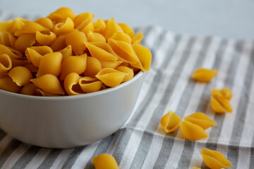 Dry Organic Medium Pasta Shells in a Bowl, side view.