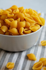 Dry Organic Medium Pasta Shells in a Bowl, side view.