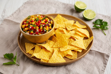 Homemade Corn Salsa with Tortilla Chips on a Plate, side view.