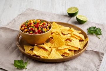 Homemade Corn Salsa with Tortilla Chips on a Plate, side view.