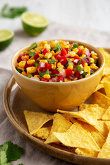 Homemade Corn Salsa with Tortilla Chips on a Plate, side view. Close-up.