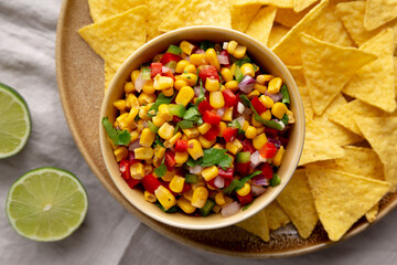 Homemade Corn Salsa with Tortilla Chips on a Plate, top view. Flat lay, overhead, from above.