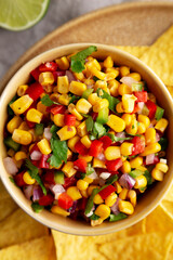 Homemade Corn Salsa with Tortilla Chips on a Plate, top view. Flat lay, overhead, from above.