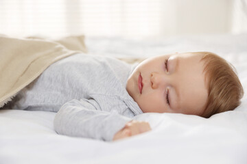 Cute little baby sleeping on bed at home