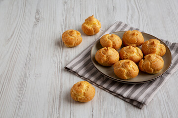 Homemade French Mini Cream Puffs on a Plate, side view. Copy space.