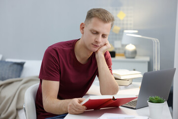 Naklejka premium Student preparing for exam at table indoors
