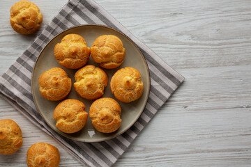 Homemade French Mini Cream Puffs on a Plate, top view. Flat lay, overhead, from above. Copy space.