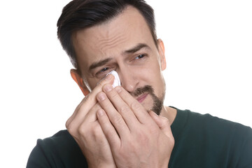 Sad man with paper tissue crying on white background