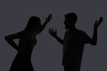 Domestic violence. Silhouette of couple quarreling on grey background