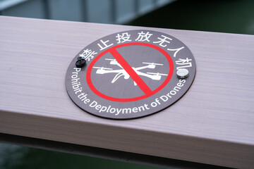  a circular sign mounted on a railing, stating 