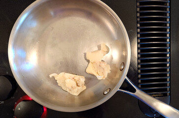 lumps of bacon grease in a stainless-steel skillet