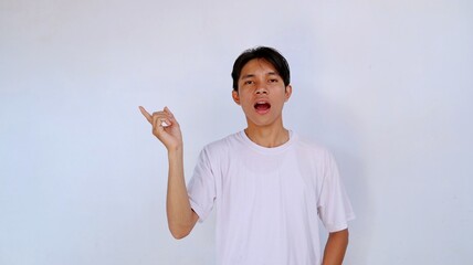 handsome asian young man shocked wearing white shirt gesture pointing sideways