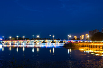 The skyline of rivers, trees, and city parks at sunset and night