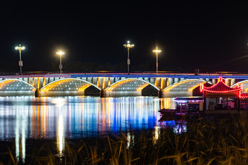 The skyline of rivers, trees, and city parks at sunset and night