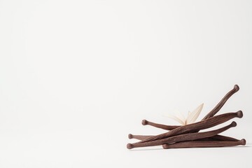 Close-up of dried vanilla pods on a clean white background showcasing their rich texture and shine