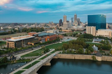 Obraz premium Downtown Indianapolis skyline at twilight, featuring the White River State Park. Public spaces and city buildings. White River, Indianapolis, Indiana, United States