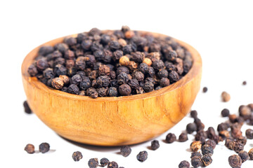 Black peppercorns (black pepper) in a wooden bowl isolated on a white background