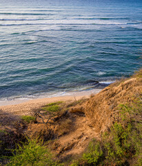 Surfers in the Distance Riding Waves near Diamond Head Lighthouse, Oahu, Hawaii.