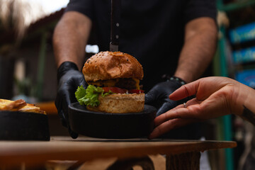 Chef Presenting a Delicious Burger to a Customer