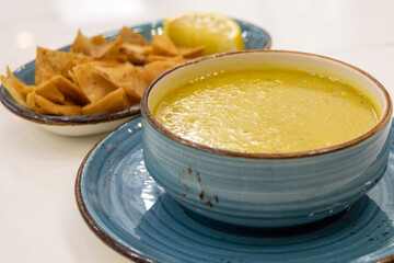 Turkish lentil soup with lemon slice and cracker