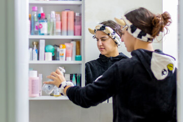 Beautiful woman choosing beauty products in her bathroom in the morning