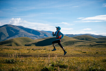Fitness woman trail runner running in grassland