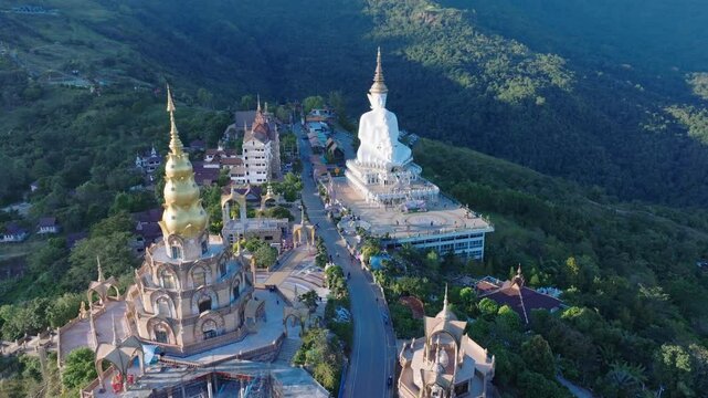 This breathtaking drone footage captures the serene mountaintop monastery and temple in northern Thailand. Featuring a white Buddha statue, golden spires and colorful mosaic tiles.