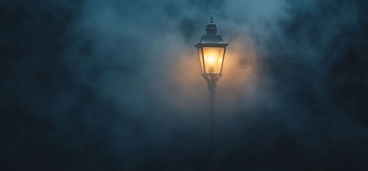 A solitary street lamp glows softly through a dense fog.