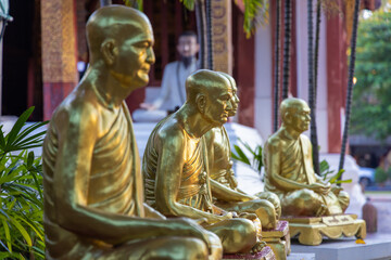 Obraz premium Golden monk statues in Wat Phra Singh Temple in Chiang Mai, Thailand