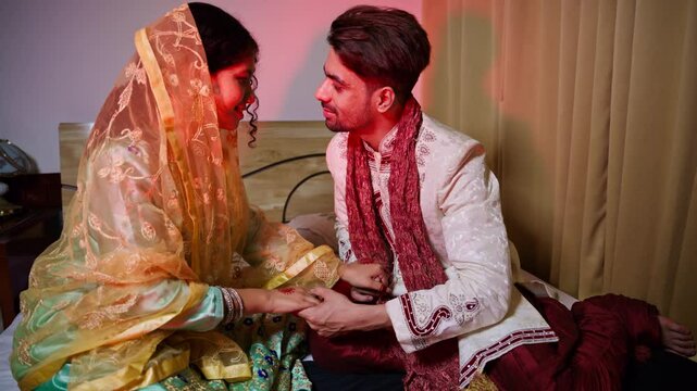 Indian newlyweds holding hands on their first night