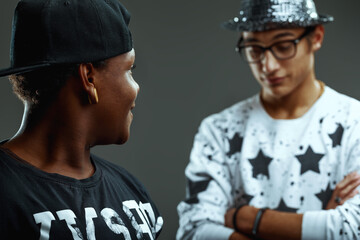 Obraz premium Two young rappers talking and exchanging opinions on grey backgr