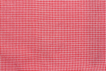 Red and white gingham fabric texture. The fabric is made up of small, square checks.