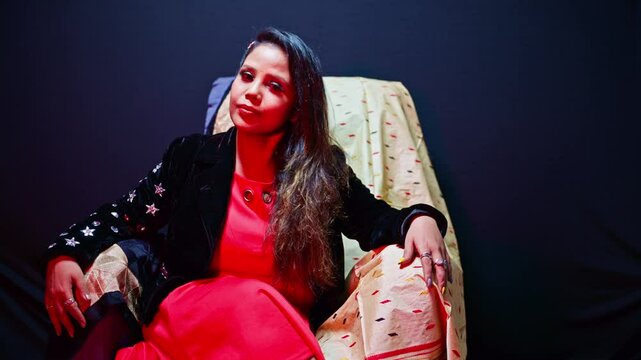Smiling model posing as sitting on chair at studio