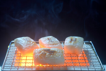 煙り立ち昇る七輪で餅を焼く