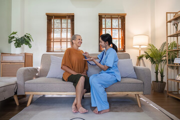 Young Nurse Providing Compassionate Health Care Advice to Elderly Woman in a Cozy Living Room Setting