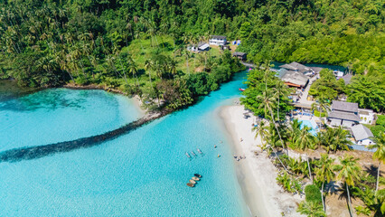 Lush tropical landscapes meet crystal-clear turquoise waters in Koh Kood, Thailand. This serene paradise invites visitors to relax on soft sandy beaches and explore vibrant marine life.