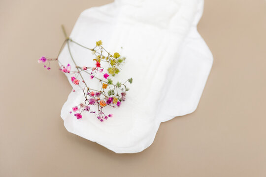 Feminine hygiene pad with colorful flowers on neutral background