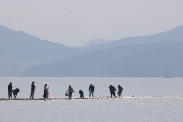 2024 Dec 26,Hong Kong ,People are seen strolling along the tombolo on Sharp Island, The tombolo is not always visible as it emerges only when low tide.