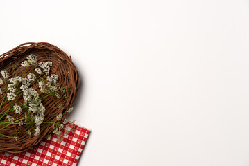 Wild flowers in a wicker basket on a white background. Flat lay, top view. Copy space