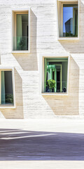 Modern architecture with large windows featuring green plants in a bright setting