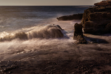 Obraz premium Waves Crashing Against Rocks on a Rugged Coastline