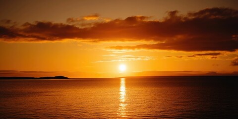 Obraz premium Fiery sunset over calm ocean waters.