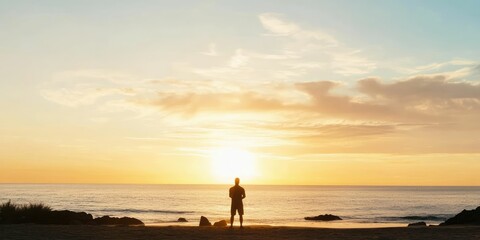 Fototapeta premium Solitary figure silhouetted against a vibrant sunset over a calm ocean.
