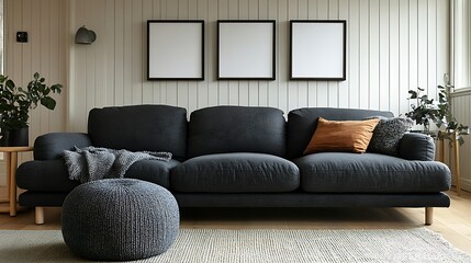 Modern living room interior with dark gray sofa, three empty frames, and plants.